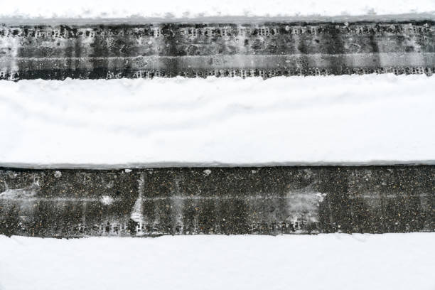 istock cleared path through deep snow on an asphalt road after a heavy snowfall 1093493596