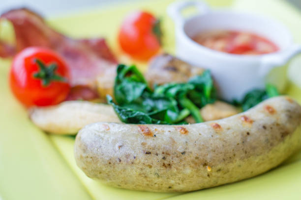 Large plate with filling breakfast, eggs sunny side up, French fries and grilled sausage