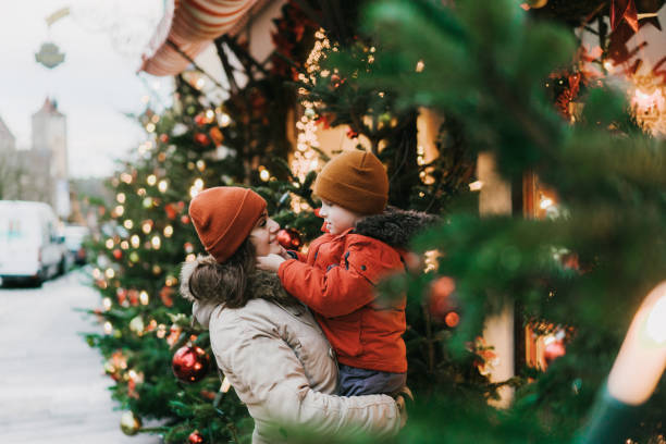 madre con figlio in piedi vicino all'albero di natale a rothenburg - christmas family child christmas tree foto e immagini stock