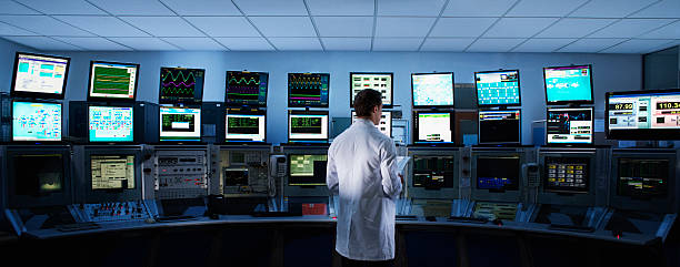 Scientist monitoring computers in control room  control room stock pictures, royalty-free photos & images