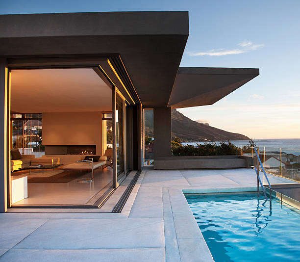 moderne salle de séjour et la terrasse à côté de la piscine - mode de vie luxueux photos et images de collection