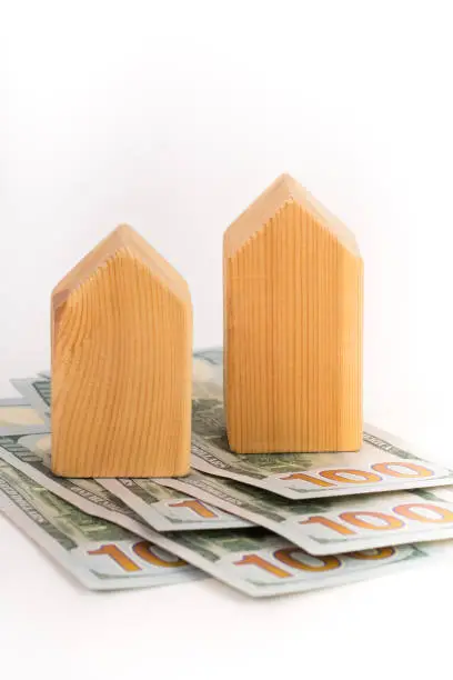 wooden house model with dollars banknotes, real estate concept