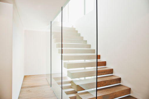 Escalera flotante y paredes de vidrio en casa moderna photo