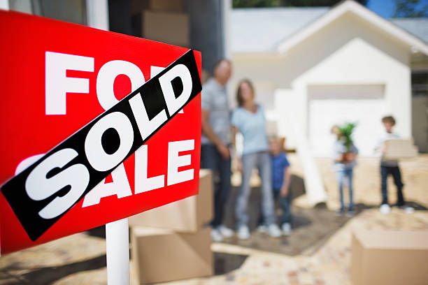 Sold sign on house with family in the background  vendor stock pictures, royalty-free photos & images