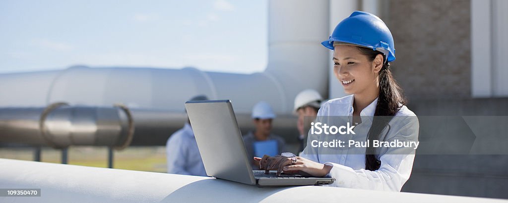 Femme d'affaires dans le chapeau dur à l'aide d'ordinateur portable en plein air - Photo de Chantier de construction libre de droits