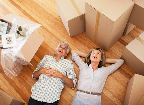 Happy couple laying on floor of new house