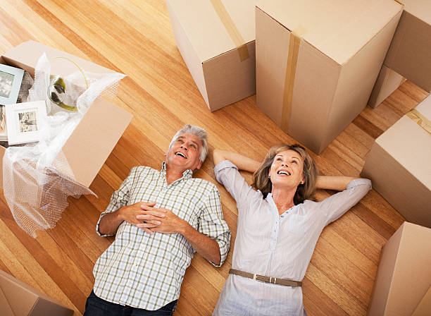 Happy couple laying on floor of new house  baby boomer stock pictures, royalty-free photos & images