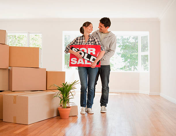 casal segurando vendidos sinal para sua nova casa - sold imagens e fotografias de stock