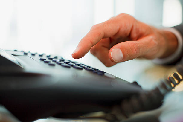 empresario marcación de teléfono en la oficina - telephone dialing human hand office fotografías e imágenes de stock