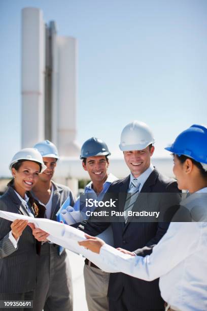 Photo libre de droit de Gens Daffaires En Examinant Les Bonnetsplan En Plein Air banque d'images et plus d'images libres de droit de Casque de chantier