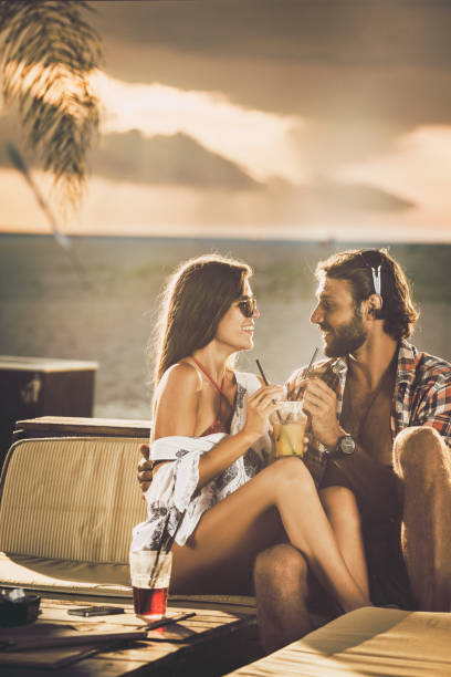 istock Happy couple talking while sharing a drink in a beach bar. 1093507504