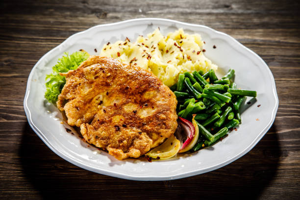 gebakken pork chop, aardappelpuree en groenten - karbonade stockfoto's en -beelden