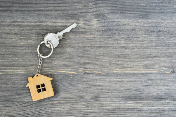 istock Metal key lock home in bamboo keychain for wooden rustic gray background. Copy space 1093507782