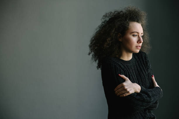 cerca de adolescente con depresión y bulimia posición solo en la habitación gris. problemas mentales con depresión y bulimia. foto blanco y negro. - drug abuse addiction women violence fotografías e imágenes de stock