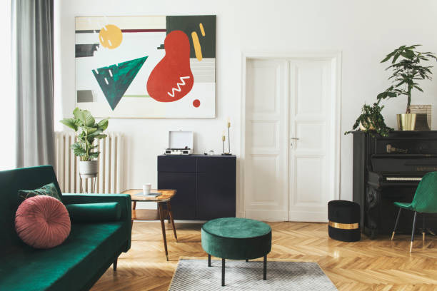 istock Luxury home interior with design velvet sofa, armchair, tables, pouf, commode and accessroies. A lot of plants on the piano. White walls with painting. Sunny view. Stylish decor of sitting room. 1093510354