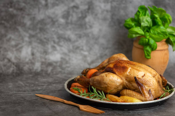 istock Roasted chicken, potatoes and vegetables in plate on grey background. Side view. With copy space 1093515590