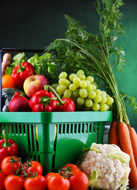 Fresh organic fruits and vegetables in plastic shopping basket Fresh organic fruits and vegetables in plastic shopping basket. feeding grapes stock pictures, royalty-free photos & images
