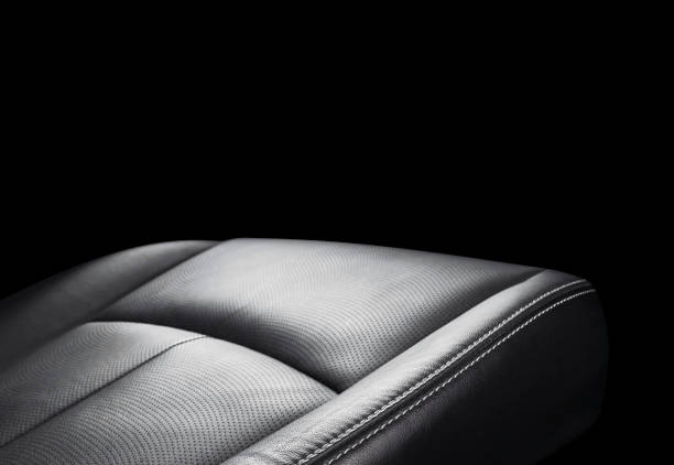 istock Black leather interior of a car. Perforated Leather comfortable seats with yellow stitching isolated on black background. Car interior details. Car detailing. Car inside 1093517342