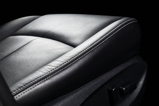 istock Black leather interior of a car. Perforated Leather comfortable seats with yellow stitching isolated on black background. Car interior details. Car detailing. Car inside 1093517470