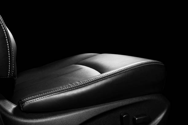 istock Black leather interior of a car. Perforated Leather comfortable seats with yellow stitching isolated on black background. Car interior details. Car detailing. Car inside 1093517644