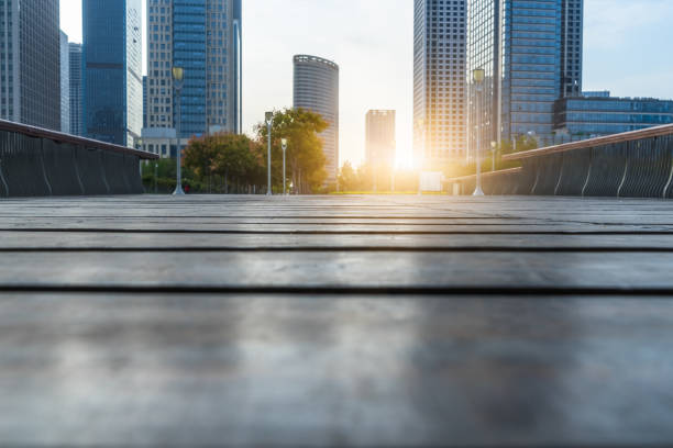 istock Low ground angle view of wooden footpath front modern building 1093520090