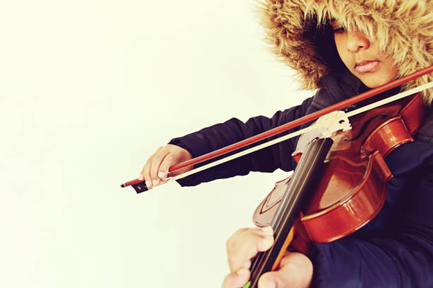 istock A boy playing the stringed and bowed musical instrument, the violin 1093521414