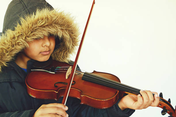 istock Horizontal capture of a boy with lovely lips playing the stringed and bowed musical instrument, the violin 1093521422