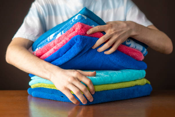 istock close up hands lay down stack of clean towels on table f 1093523138