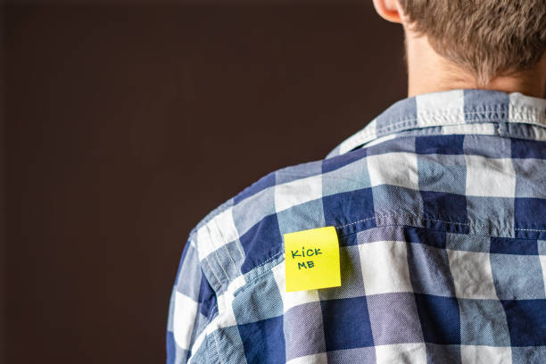 istock hand glue yellow kick me sticker on persons back at aprill fool day b 1093523208