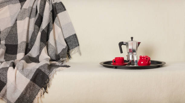 istock Round black metal tray with a coffee maker and a cup on a white sofa with a gray plaid and pillows. 1093526372