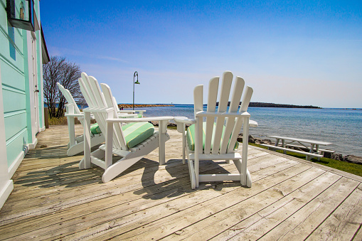 Adirondack chairs on a wooden deck with a view of Lake Huron at the Mackinaw Island Public Library.