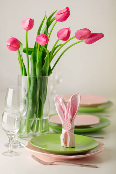 istock Happy easter. Decor and table setting of the Easter table is a vase with pink tulips and dishes of pink and green color. 1093532632
