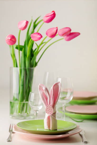 istock Happy easter. Decor and table setting of the Easter table is a vase with pink tulips and dishes of pink and green color. 1093532642