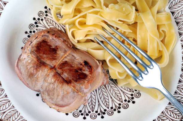 Veal paupiettes and tagliatelle on a plate seen from above