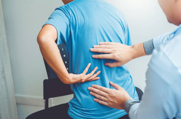 istock Doctor consulting with patient Back problems Physical therapy concept 1093541020