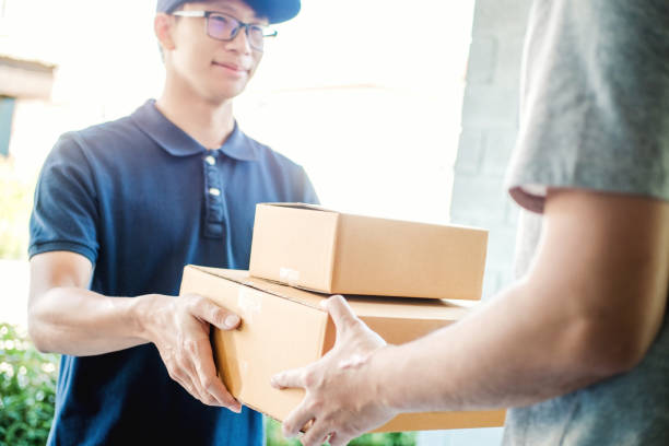 istock Asian Man hand accepting a delivery boxes from professional deliveryman at home 1093541306