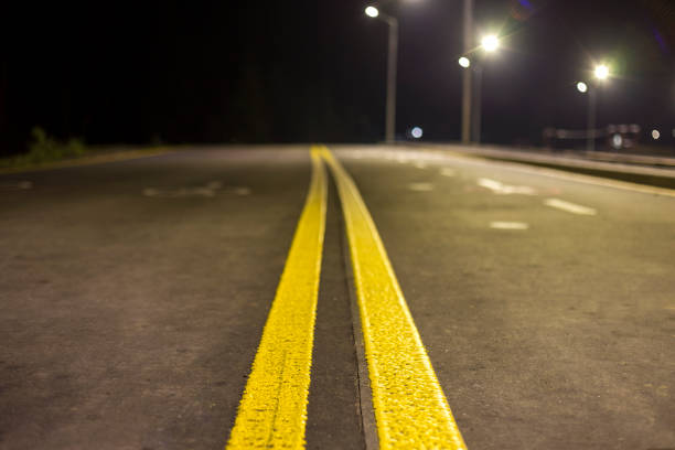 istock Wide modern smooth empty illuminated with street lamps asphalt highway with bright white marking sign line at night. Speed, safety, comfortable journey and professional road building concept. 1093544304