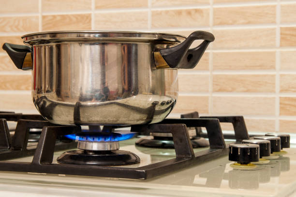 istock Metal cooking pot standing on kitchen stove with flame. 1093548898