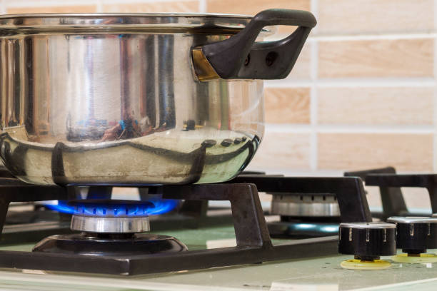 istock Metal cooking pot standing on kitchen stove with flame. 1093548912