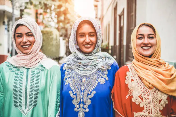 Portrait of arabian girls outdoor in city street - Young islamic women smiling on camera - Youth, friendship, religion and culture concept - Focus on faces