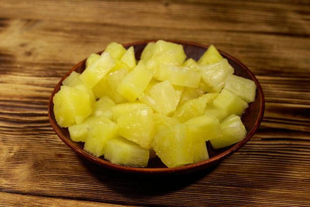 istock Canned pineapple pieces in ceramic plate on wooden table 1093557044