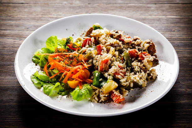 istock White rice with meat and vegetables on wooden background 1093558576