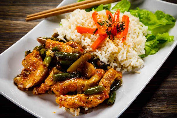 istock White rice with meat and vegetables on wooden background 1093559028