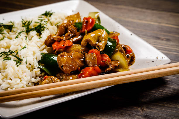 istock White rice with meat and vegetables on wooden background 1093559778