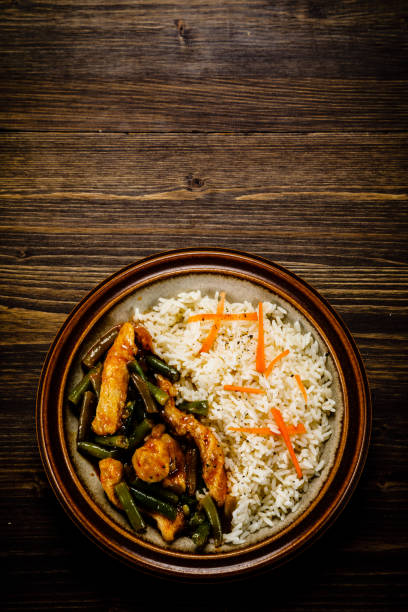 istock White rice with meat and vegetables on wooden background 1093561238