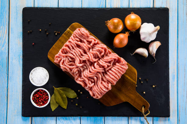 istock Raw minced meat, vegetables and seasonings on stone background 1093562218