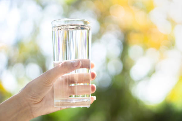 istock woman hand holding fresh water drinking glass 1093567310