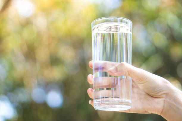 istock woman hand holding fresh water drinking glass 1093567368