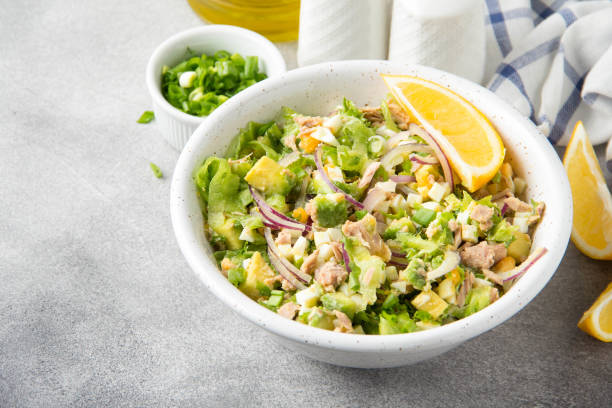 istock Salad with tuna, avocado, onion, egg and lemon. Spring healthy delicious lunch on light background 1093570184