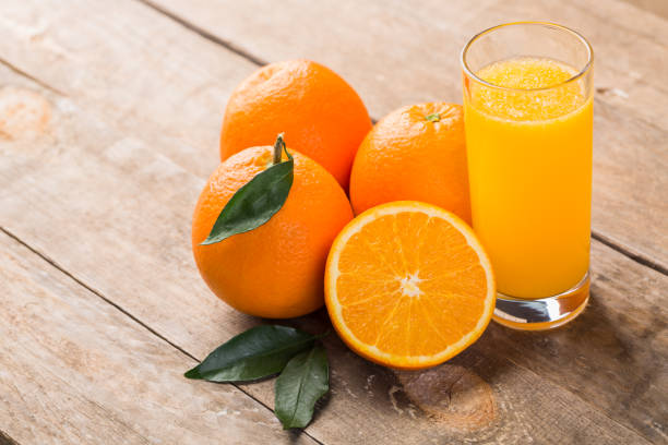 istock Orange juice with orange and green leaf on wooden table 1093574966
